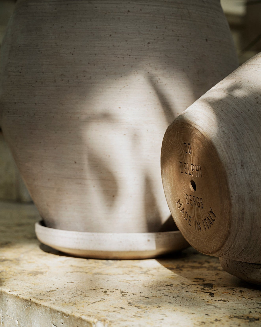 Two ceramic pots on a stone surface with 'Elle & Hem' branding.