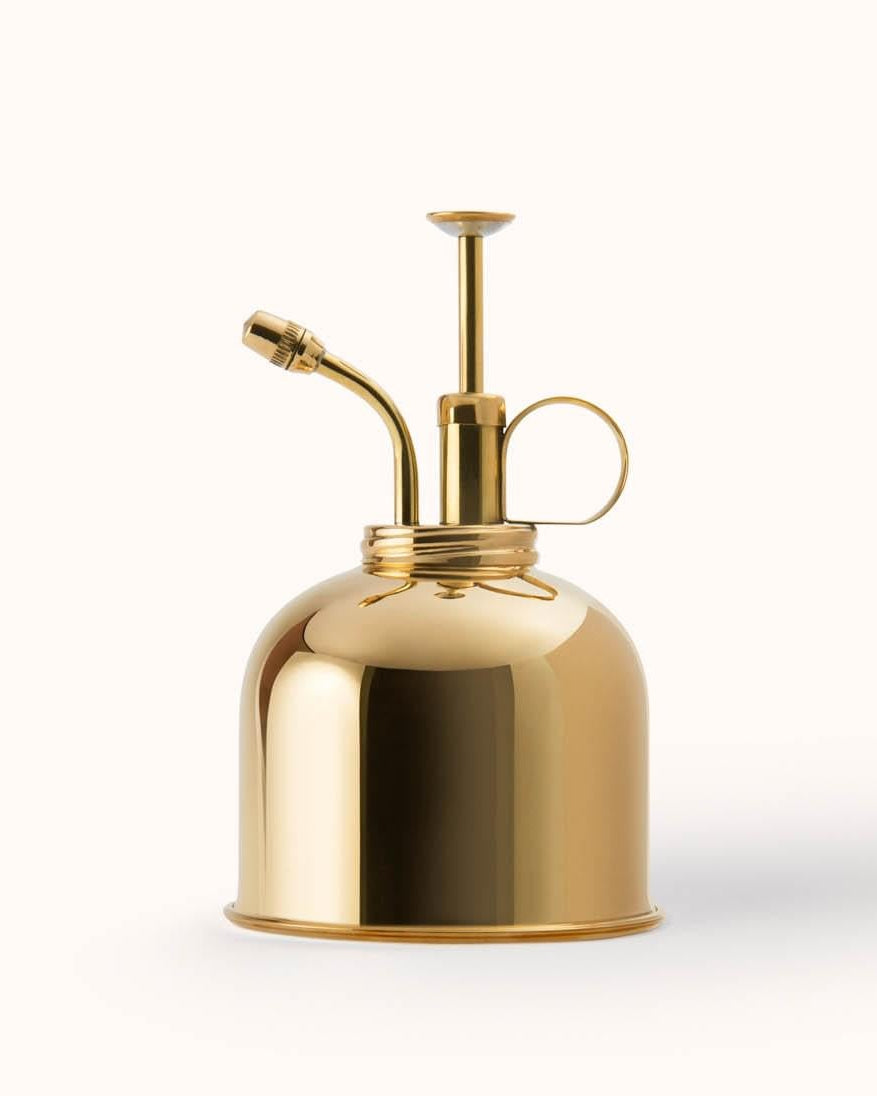 Gold-colored spray bottle on a white background