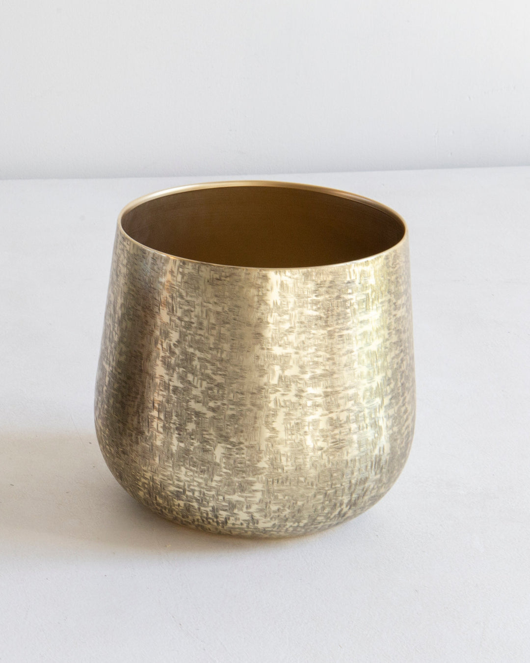 Two metallic cups, one dark and one gold, on a white surface with a white background.