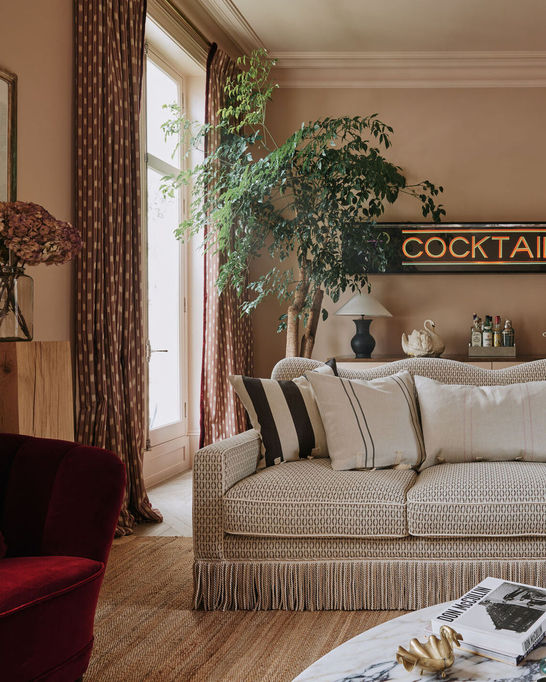 Living room with a beige sofa, red armchair, and decorative elements.